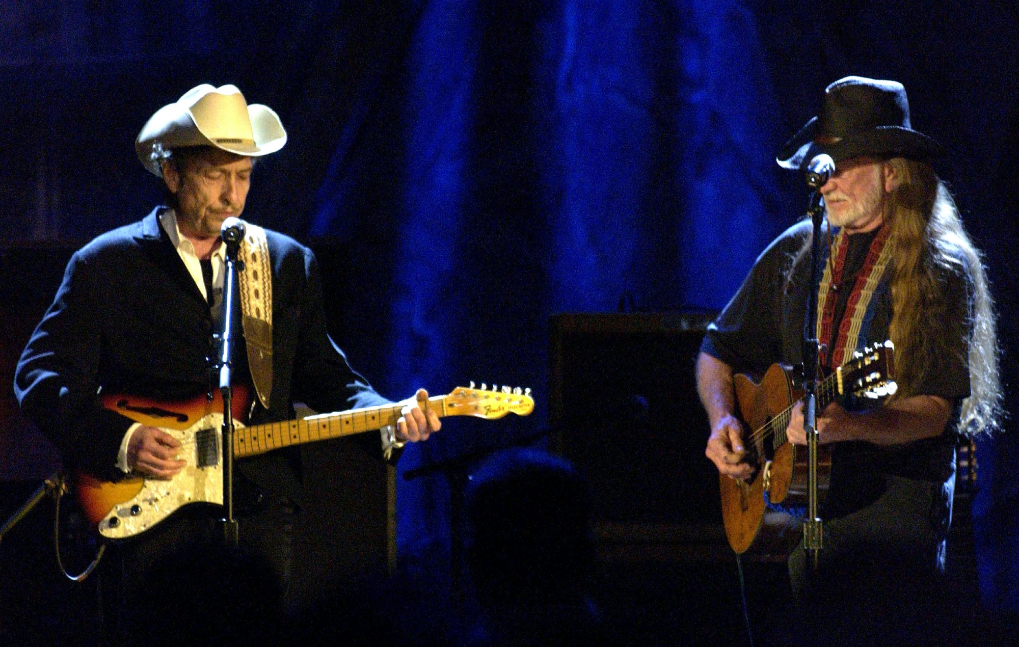 Bob Dylan and Willie Nelson performing on stage together, photo by M. Caulfield/WireImage/Getty