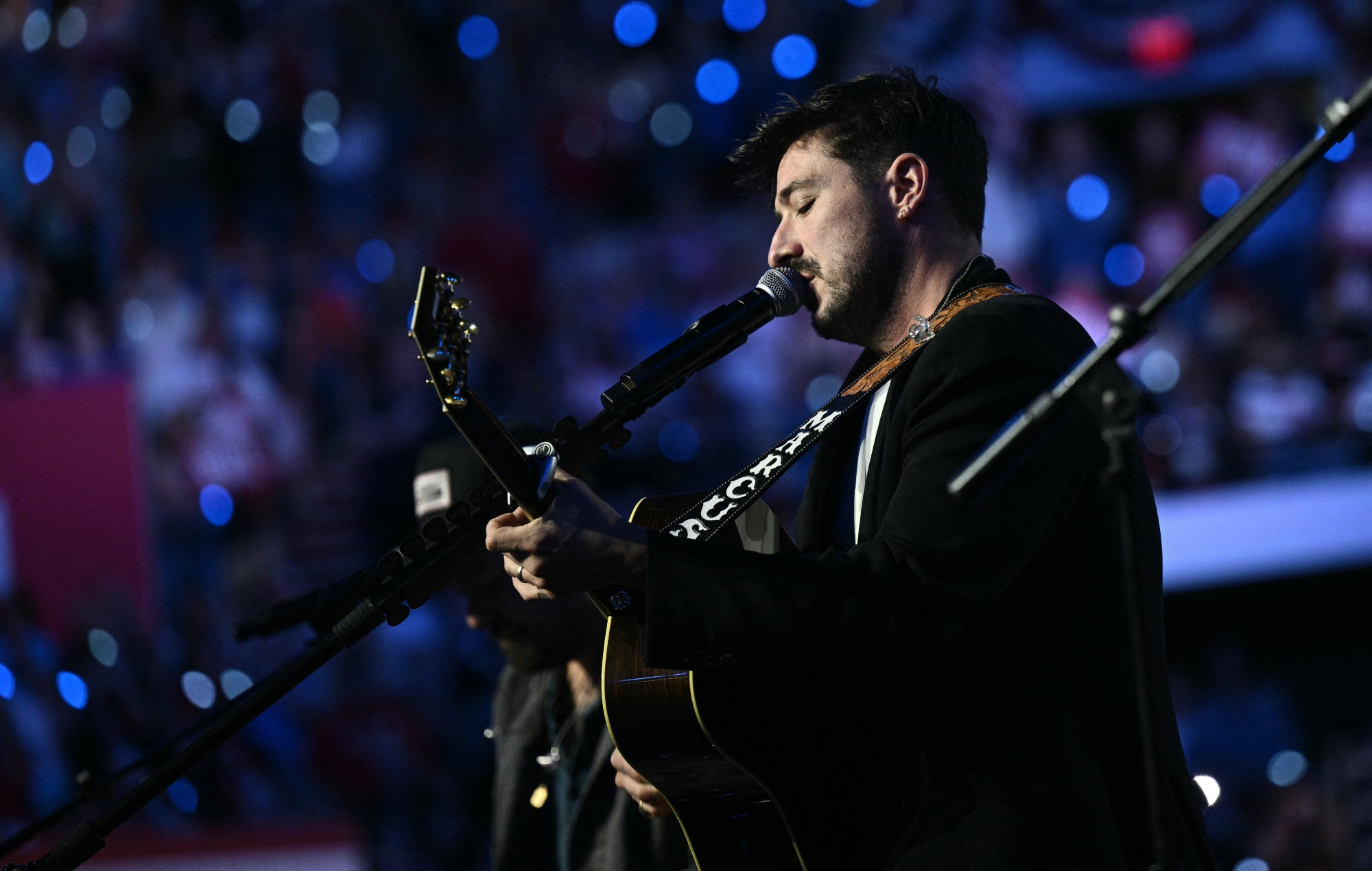 Marcus Mumford performing live on stage with Mumford & Sons
