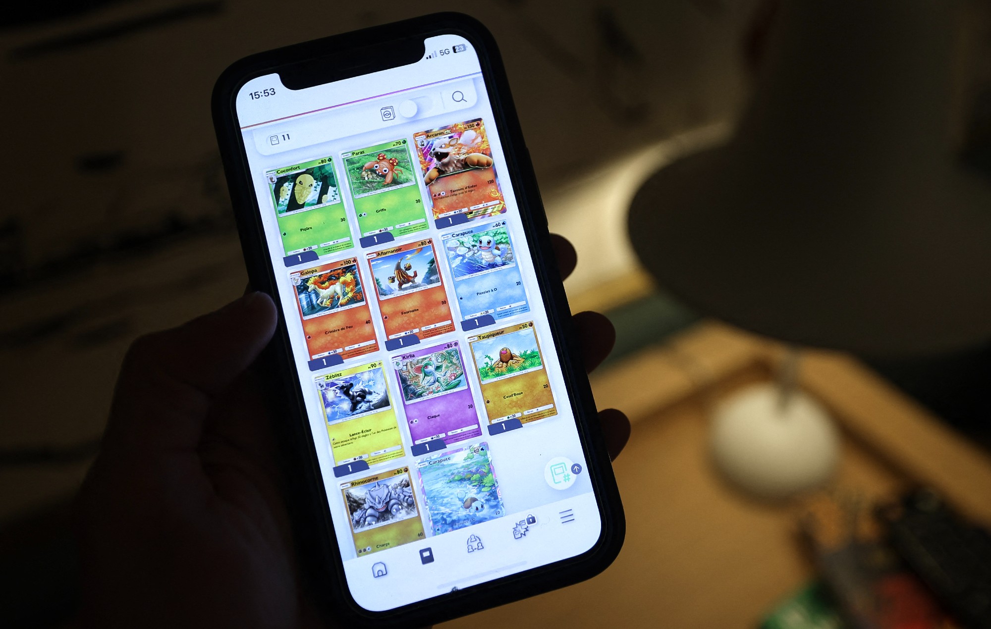Gamer plays Pokémon Pocket on mobile phone.
