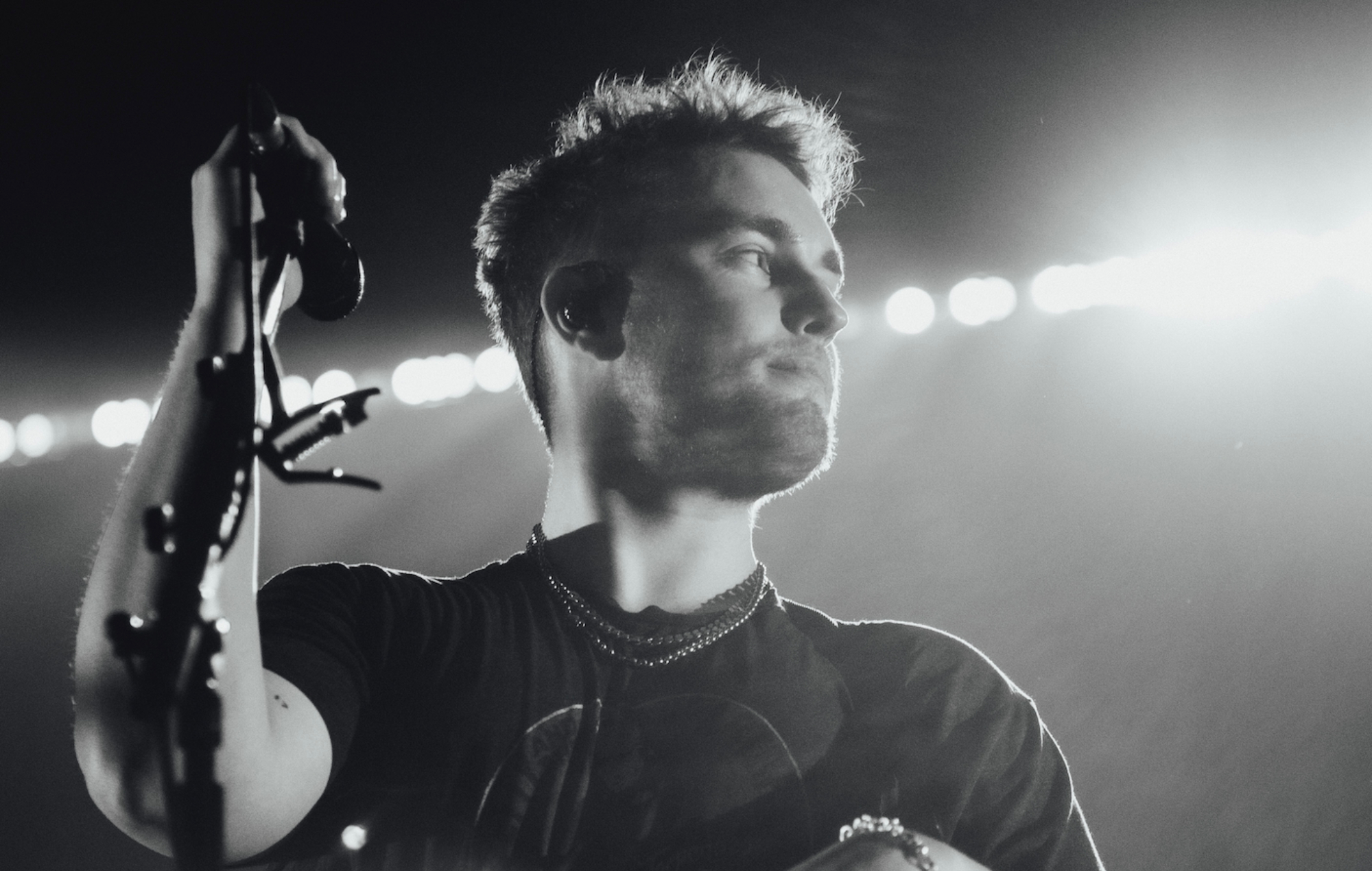 black and white picture of Sam Fender performing live on stage