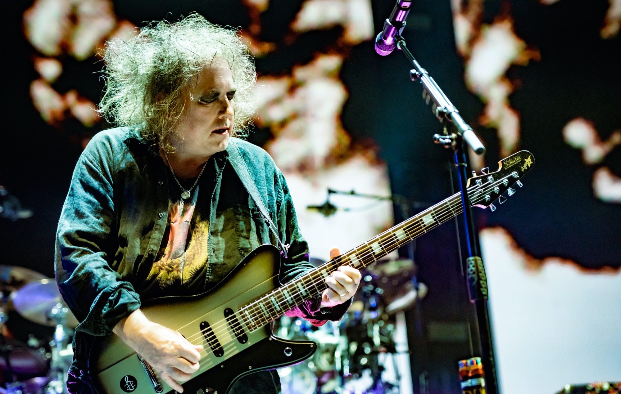 Robert Smith performing live on stage with The Cure