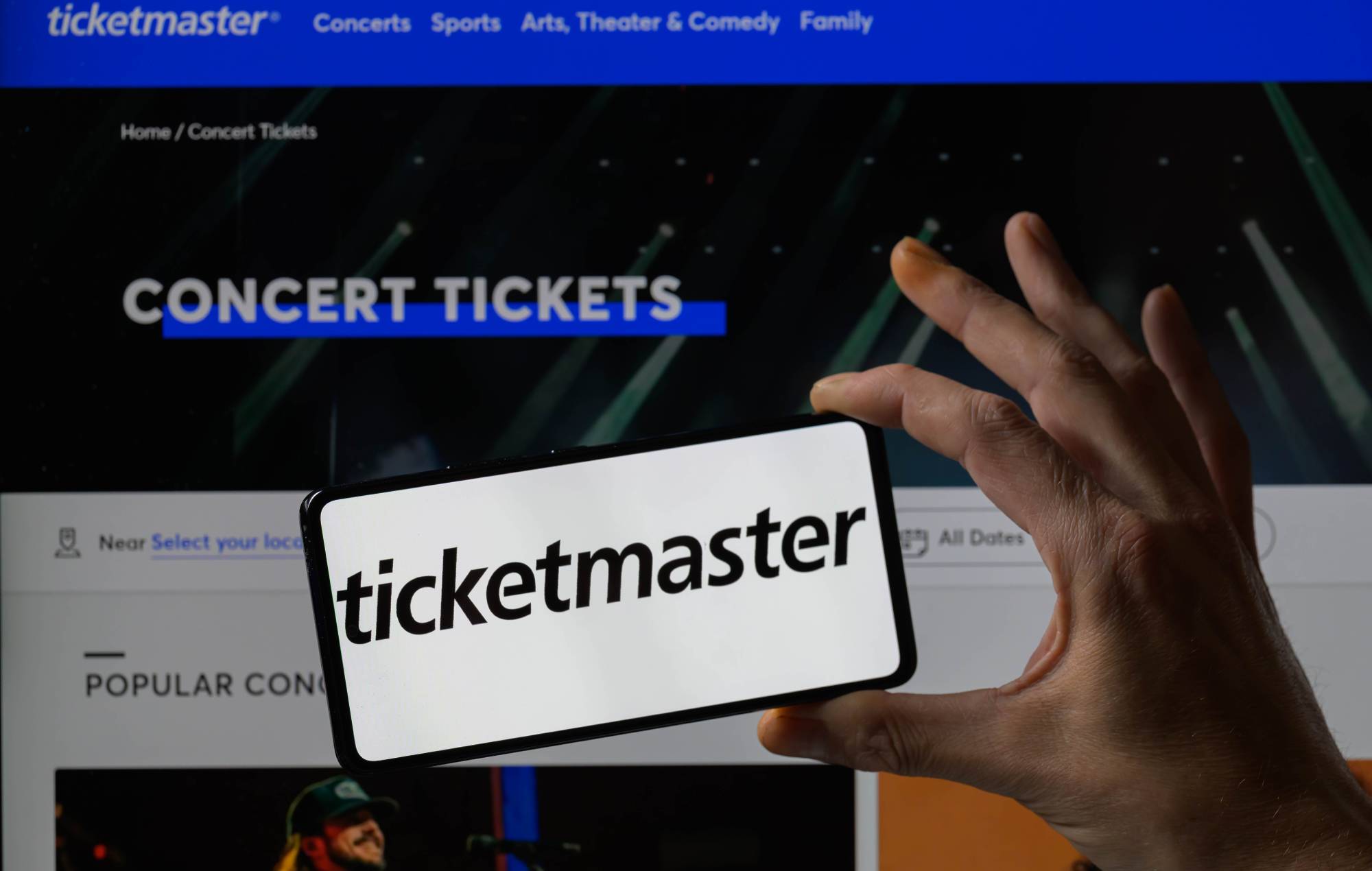 Ticketmaster logo is being displayed on a smartphone with the Ticketmaster web home page visible in the background. (Photo by Jonathan Raa/NurPhoto via Getty Images)