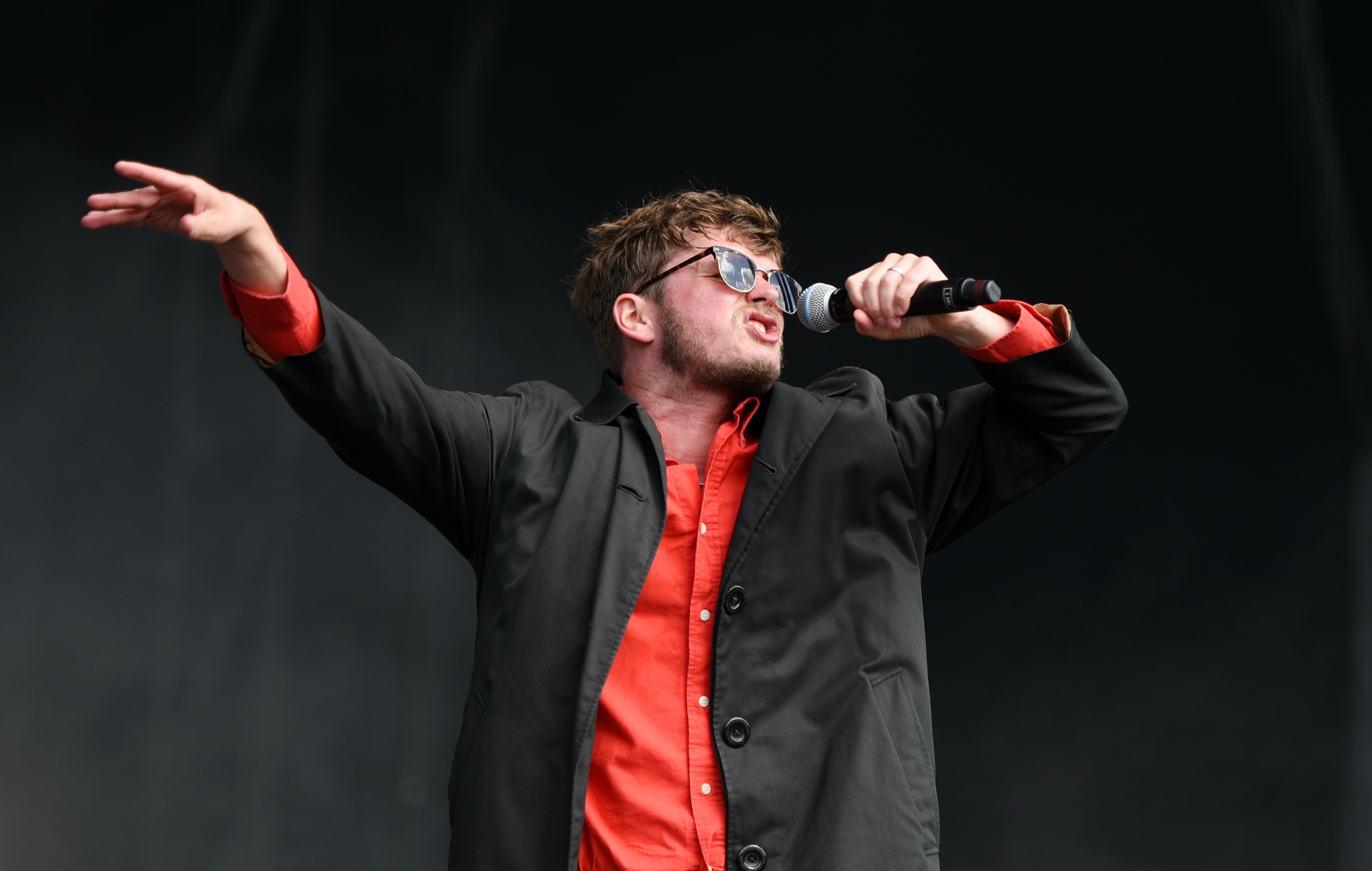 James Smith performing live on stage with Yard Act