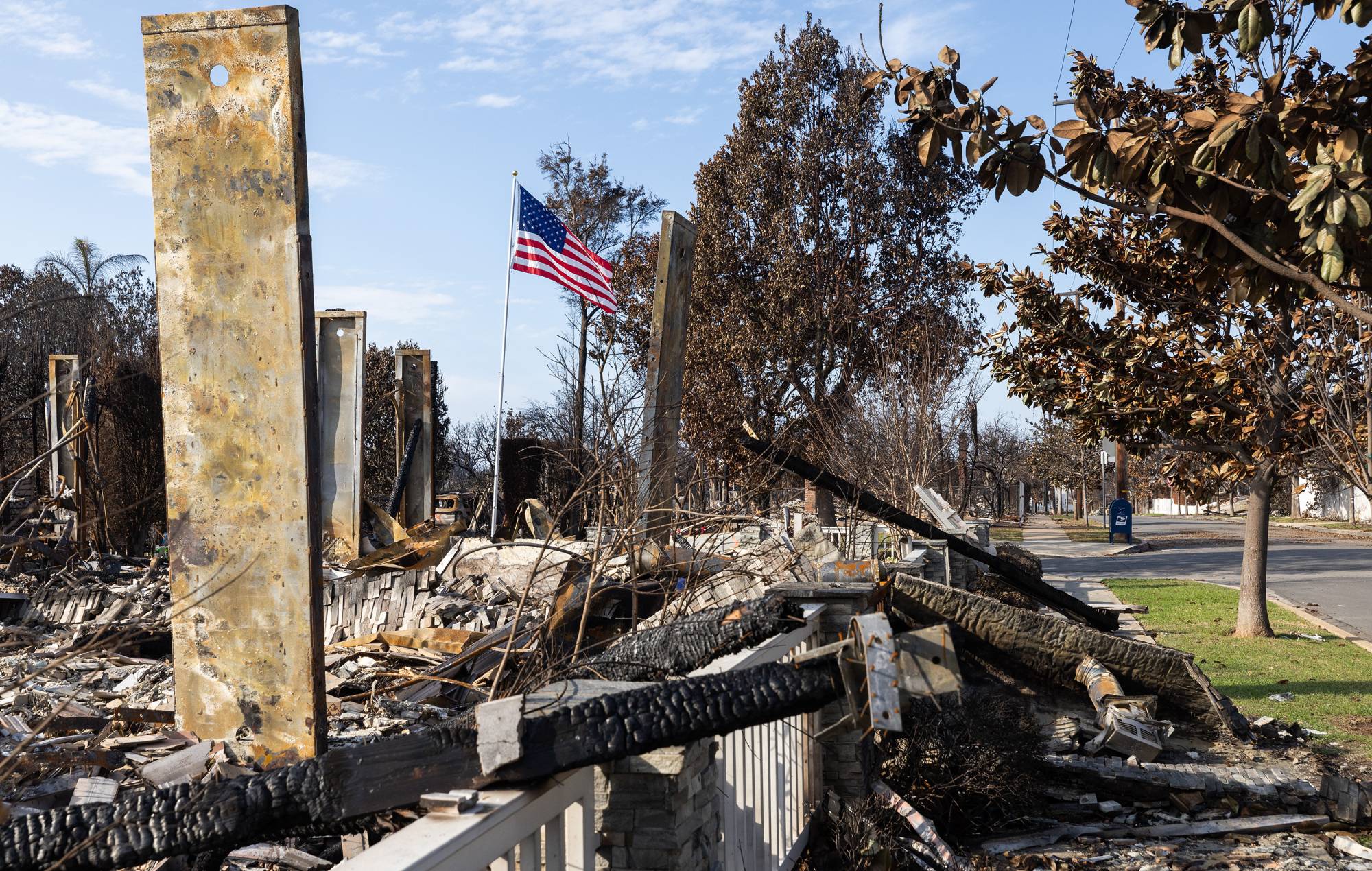 A flag flies at a destroyed house on Galloway Street in Pacific Palisades, CA (Myung J. Chun / Los Angeles Times via Getty Images)